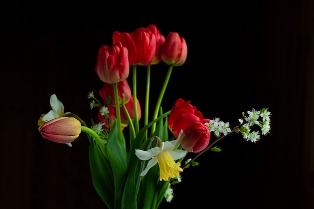Boeket van rode tulpen en narcissen in een vaas