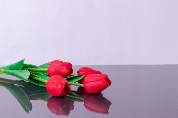 Boeket van rode tulpen op tafel met reflex