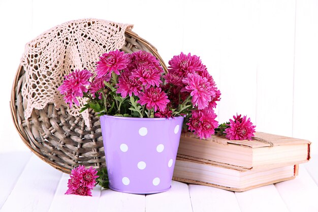 Boeket van roze chrysant in emmer op witte houten achtergrond