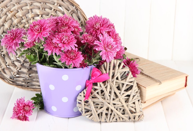 Boeket van roze chrysant in emmer op witte houten achtergrond