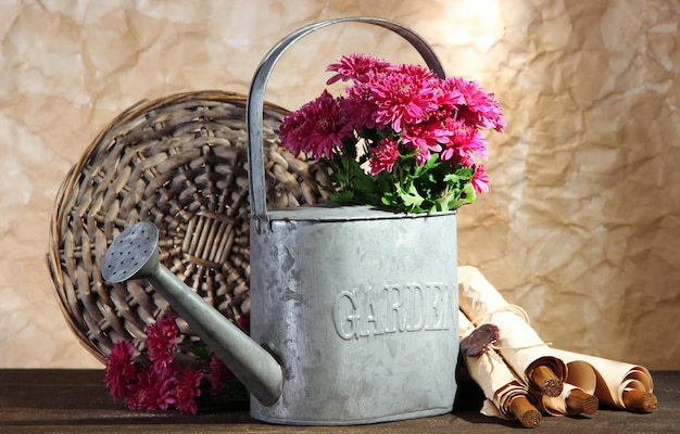 Boeket van roze chrysant in gieter op houten tafel