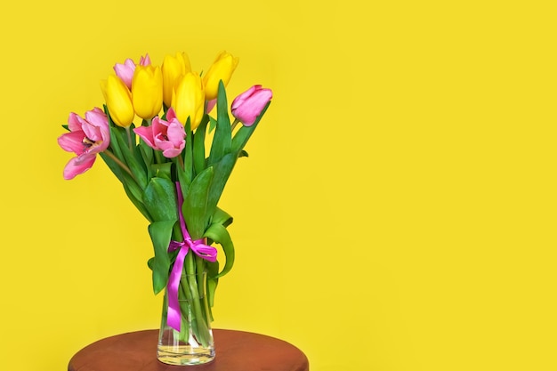 Boeket van roze en gele tulpen op gele ondergrond