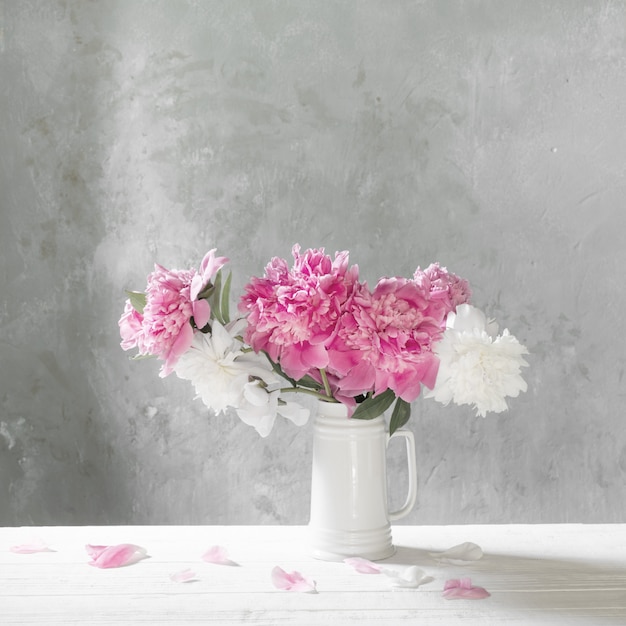 Boeket van roze en witte pioenen op oude muur als achtergrond