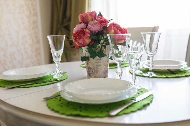 Boeket van roze pioenrozen bloemen op een tafel met bestek