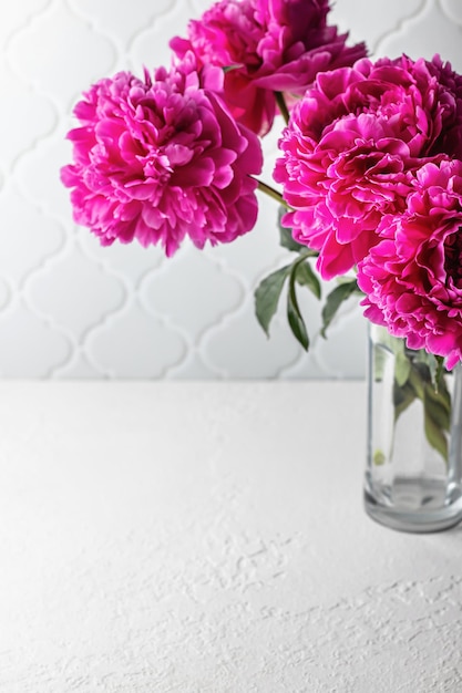 Boeket van roze pioenrozen op een witte tafel Minimalistische stilleven zomer achtergrond met kopie ruimte