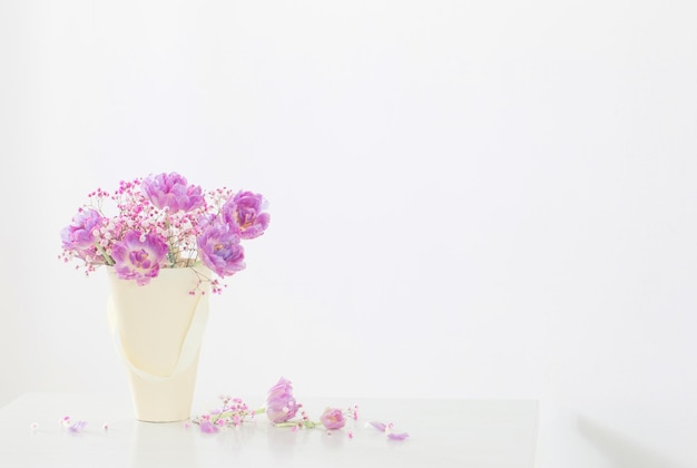 Boeket van roze tulpen en gipskruid op witte tafel