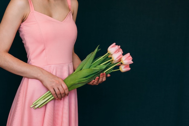 Boeket van roze tulpen in handen van vrouwen