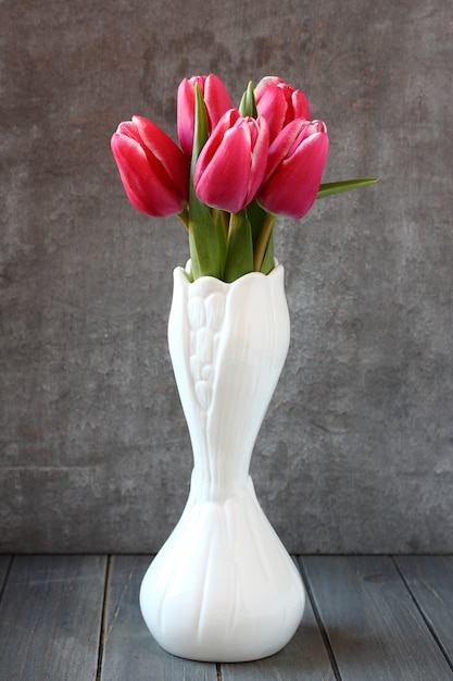 Foto boeket van roze tulpen in witte vaas op houten achtergrond