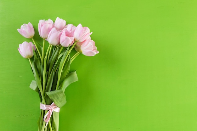 Boeket van roze tulpen op een groene achtergrond.