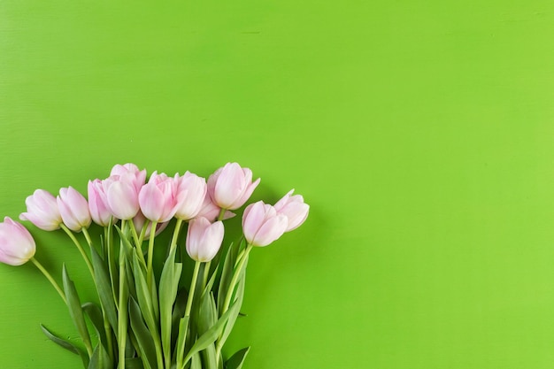 Boeket van roze tulpen op een groene achtergrond.