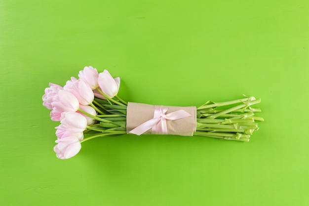 Boeket van roze tulpen op een groene achtergrond.