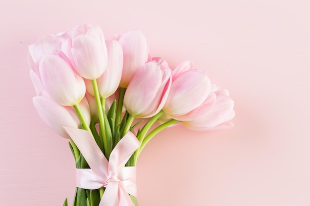 Boeket van roze tulpen op een roze achtergrond.