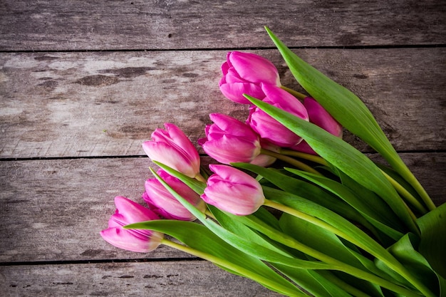 Boeket van roze tulpen op een rustieke houten achtergrond