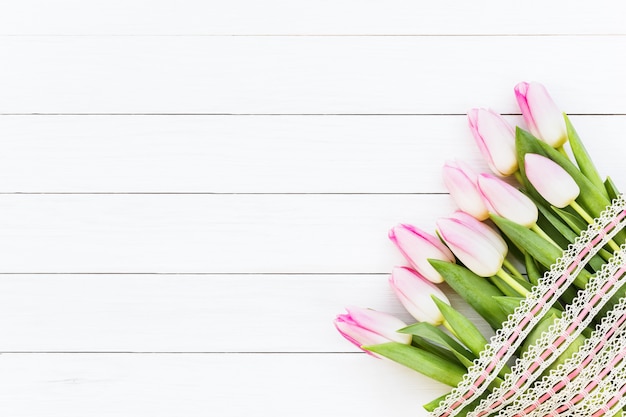 Boeket van roze tulpen op witte houten achtergrond. Bovenaanzicht