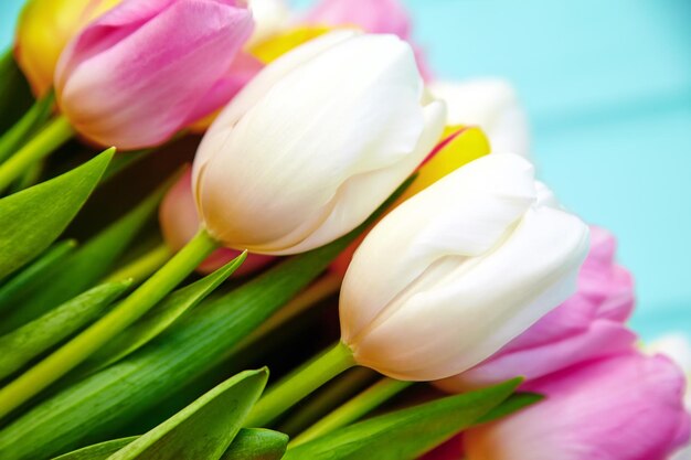 Boeket van verse veelkleurige tulpenbloemen op oude blauwe houten tafel