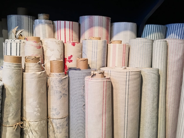 Boeket van warme gebreide pastelkleuren van diverse stoffenpatronen in een stapel op wit.