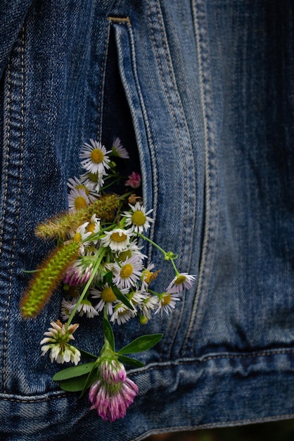 Boeket van wilde bloemen in de zak van een spijkerbroek