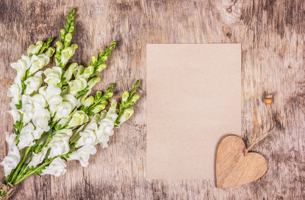 Foto boeket van witte bloemen en romantische brief.