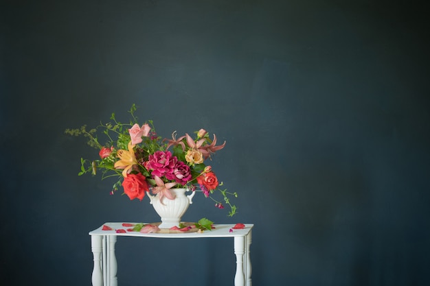 Boeket van zomerbloemen in vaas op vintage witte houten plank op donkere achtergrond