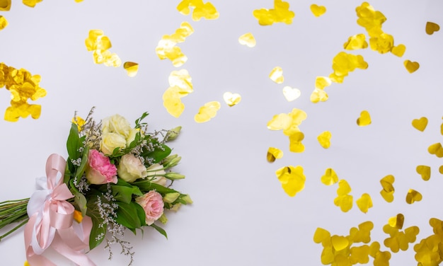 Boeket verse bloemen op een witte achtergrond met confetti