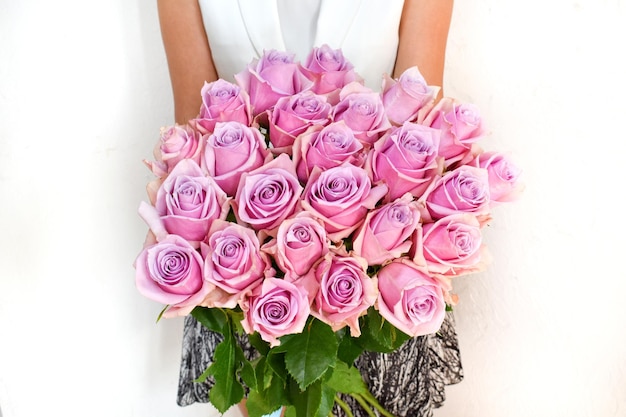 Boeket verse roze rozen in de handen van vrouw Mooie verse bloemen voor vakantie Vrouw met bloemen binnenshuis