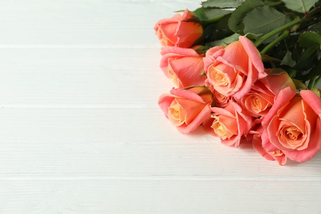 Boeket verse roze rozen op houten tafel, close-up