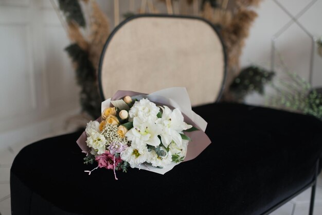 Boeket witte bloemen op een zwarte bank in het interieur