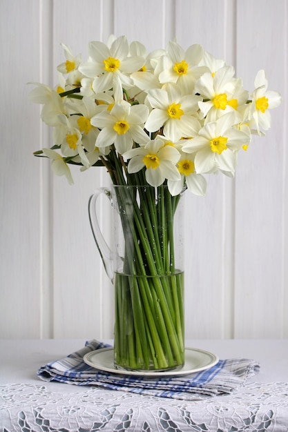 Boeket witte narcissen in een glazen kan