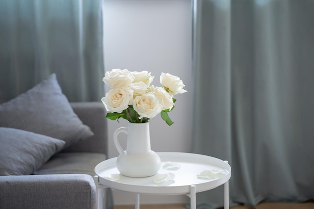 Boeket witte rozen in witte kruik in modern interieur