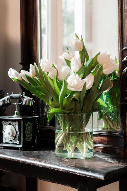 Boeket witte tulpen in een vaas bij de spiegelruimte voor tekst