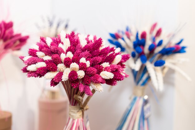 Boeketten van roze en blauwe wilde gedroogde gestabiliseerde bloemen in de winkel. Floristische samenstelling