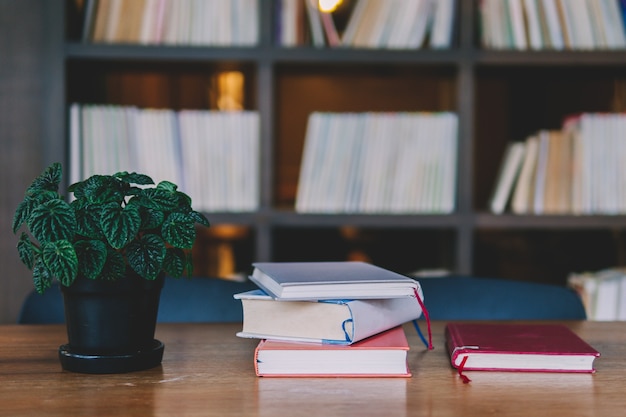 Foto boekstapel op houten lijst met boekenplank is achtergrond bij bibliotheek