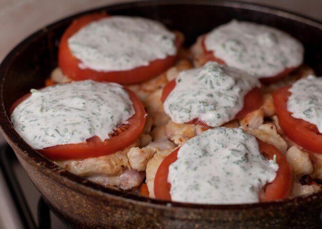 Boekweit met vlees en tomaten met witte saus in een koekenpan