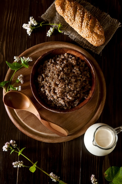 Boekweithavermoutpap, melk en brood op bruine houten achtergrond