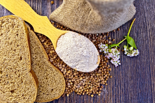 Boekweitmeel in een houten lepel, boekweit in de zak, sneetjes brood, boekweitbloem op de achtergrond van houten planken erop