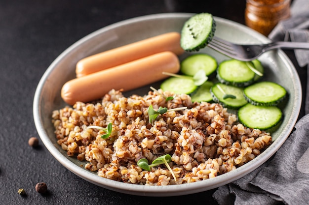 Boekweitpap en worstjes verse komkommersalade dieetmaaltijd snack op tafel kopieer ruimtevoedsel