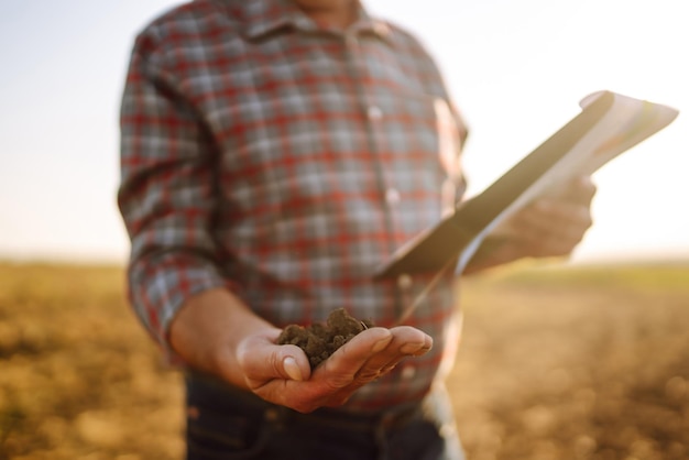 Boer controleert de bodemkwaliteit voordat hij gaat zaaien. Landbouw-tuinieren of ecologie-concept