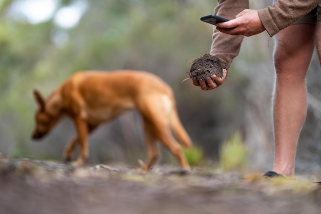 Foto boer die bodem in de hand houdt en bodem op de grond giet verbonden met het land en de omgeving bodemagronomie in australië bodemheath studie