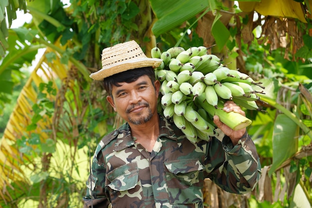 Boer draagt ​​groene bananen