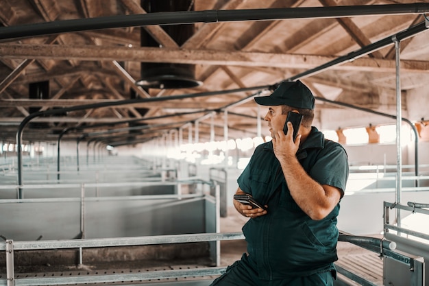 Boer met behulp van slimme telefoon en dierenverdeler bellen