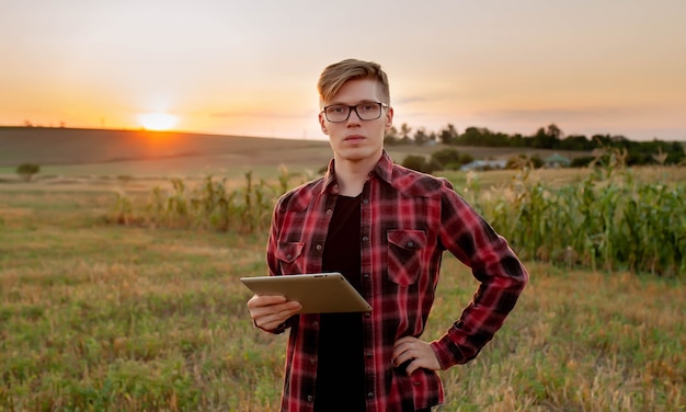 Boer met tablet bij zonsondergang in het veld, landbouw management concept