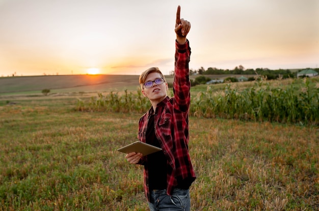 Boer met tablet bij zonsondergang in het veld, landbouw management concept