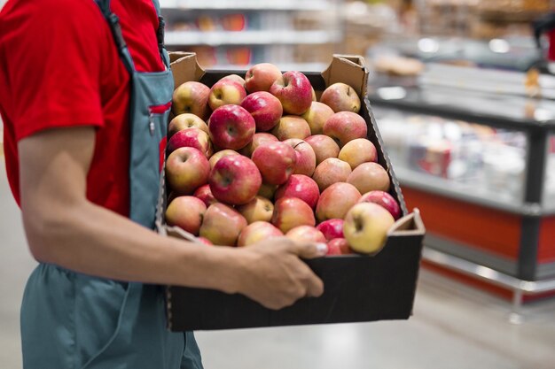 Boer met vers geoogste appels in kartonnen doos. landbouw en tuinieren concept.