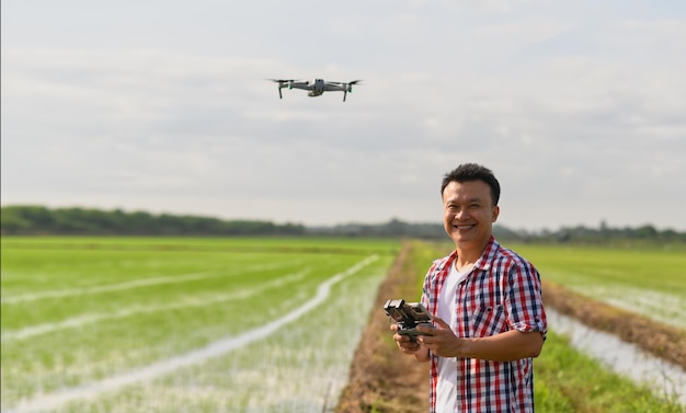Boer navigeert met drone boven landbouwgrond Hoogtechnologische innovaties voor het verhogen van de productiviteit in de landbouw