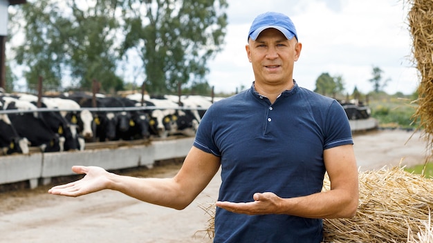 Boer werkt op de boerderij met melkkoeien