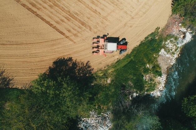 Boer zaait en zaait gewassen op het veld Zaaien is het proces van het planten van zaden in de grond Drone Photo