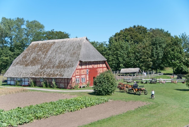 Foto boerderijhuis en bomen tegen een heldere blauwe hemel