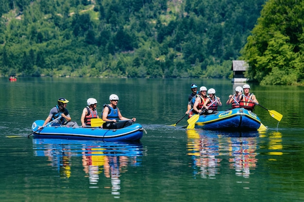 Bohinj, Slovenia - June 3, 2019: Scenery of man canoeing at Bohinj Lake in Slovenia. Nature and people kayaking on water in Slovenija. Beautiful landscape view in summer. Alpine Julian Alps mountains