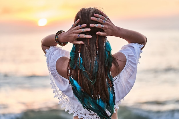 Boho hippie woman with blue feathers in hair