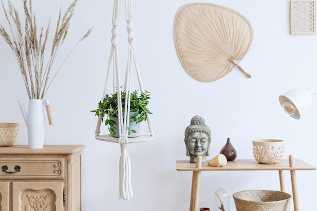 Foto boho interieur van open ruimte met houten bureau en persoonlijke accessoires botanisch en minimalistisch